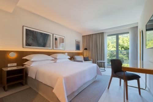 a hotel room with a large bed and a desk at Bluesun Hotel Elaphusa in Bol