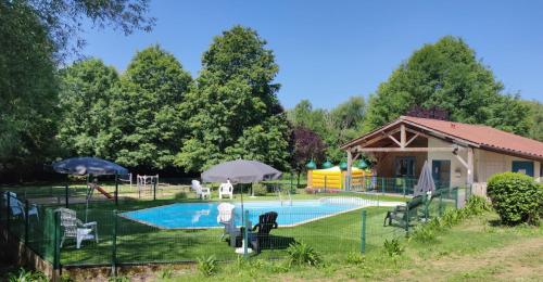 - une piscine avec un kiosque et une maison dans l'établissement Camping Le Hameau du Petit Lay, à Mouchamps