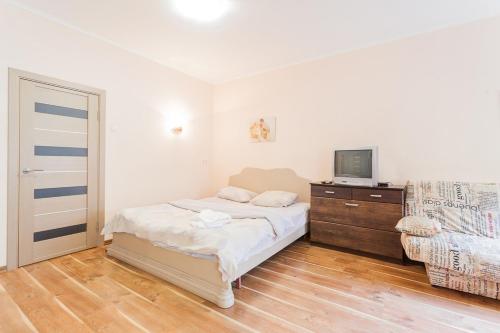 Schlafzimmer mit einem Bett, einem TV und einer Kommode in der Unterkunft Cozy apartments near Olympic Stadium in Kiew