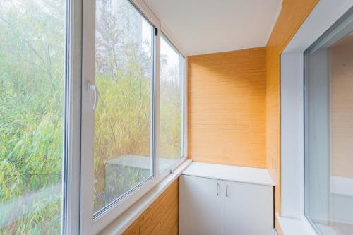 ein kleines Zimmer mit einem Fenster und einem weißen Schrank in der Unterkunft Cozy apartments near Olympic Stadium in Kiew