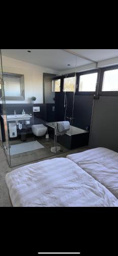 een slaapkamer met een groot bed en een badkamer bij Wohnung mit besonderem Ausblick in Pfaffenhausen