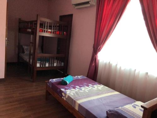 a bedroom with a bed and a window and a book shelf at HOMESTAY D' SEPANGAR HILLS in Kota Kinabalu