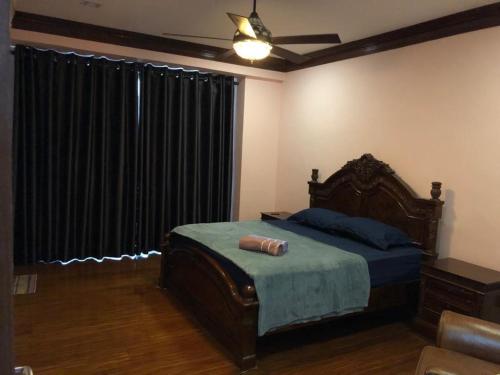 a bedroom with a bed and a window with black curtains at HOMESTAY D' SEPANGAR HILLS in Kota Kinabalu
