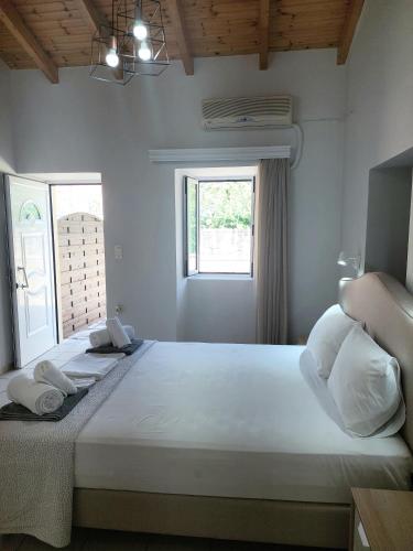 a bedroom with a large white bed with two pillows at Electra Villa & Pool Studios in Gaios