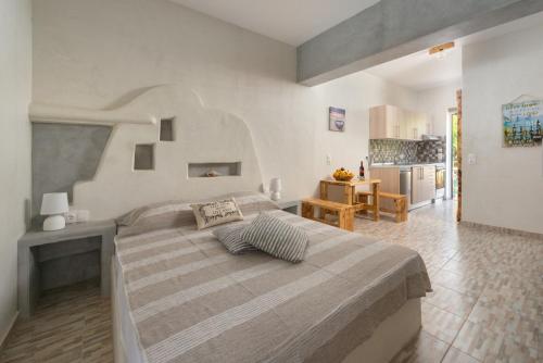 a bedroom with a large bed and a kitchen at Christos studios and family apartments in Rhodes Town