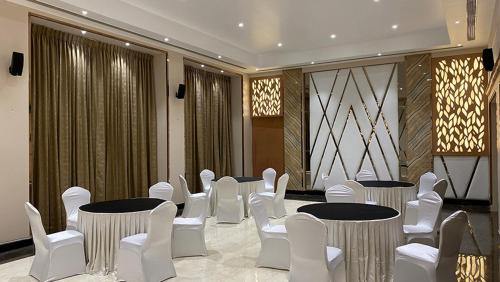 a group of tables and chairs in a room at Quality Inn VIHA in Kumbakonam