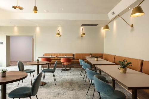 a restaurant with wooden tables and blue chairs at voco Venice Mestre - The Quid by IHG in Mestre