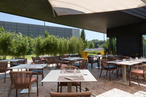 an outdoor dining area with tables and chairs at voco Venice Mestre - The Quid by IHG in Mestre