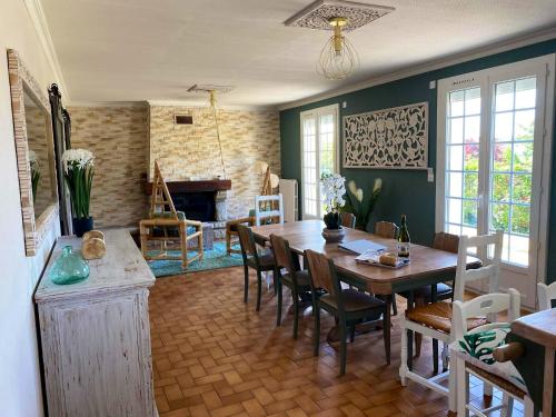 une salle à manger avec une table et des chaises et une cheminée dans l'établissement Maison vue mer à Plouguerneau, à Plouguerneau