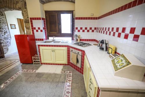 una cucina con piano di lavoro piastrellato rosso e bianco di Dimora dei Greci a Paestum