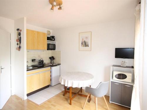 a kitchen with a table and a small kitchen with a table and chairs at Studio Bagnères-de-Luchon, 1 pièce, 4 personnes - FR-1-313-148 in Luchon