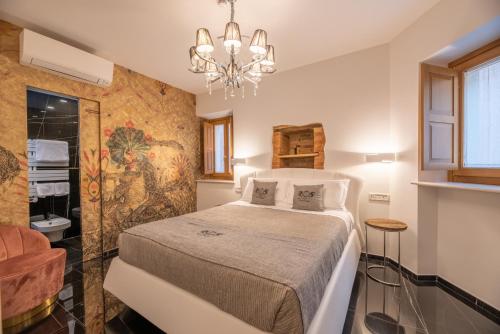 1 dormitorio con cama y lámpara de araña en B&B Rocca del Civitillo, en Notaresco