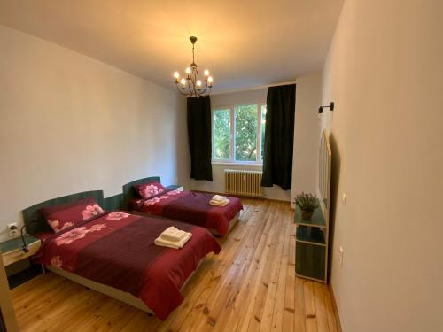 Un dormitorio con dos camas y una lámpara de araña. en 113 in Sofia with 2BR and 2 full bath, en Sofía