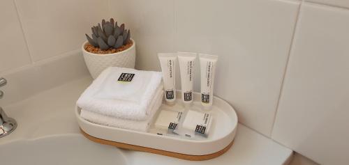 a white toothbrush holder on a counter with a plant at Buln Buln Cabins in Yanakie