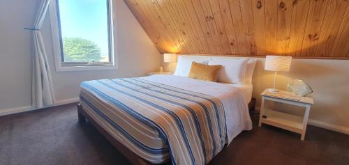 Buln Buln Cabins في ياناكي: غرفة نوم بسرير كبير مع نافذة