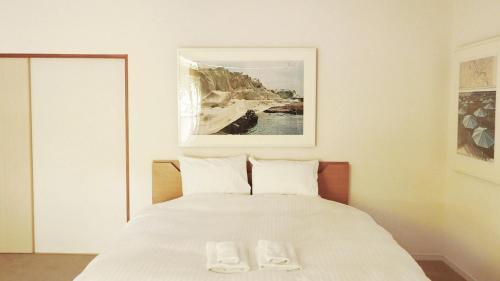 a bedroom with a bed with two white towels on it at Akizuki Gallery House in Asakura