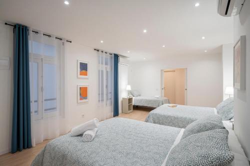 a white room with two beds and a window at Room Plaza España in Madrid