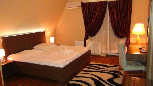 a bedroom with a bed and a desk and a window at Penzion Vila Aria in Nitra