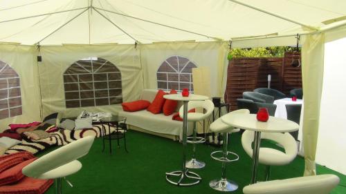 a tent with a couch and tables and chairs at Penzion Vila Aria in Nitra
