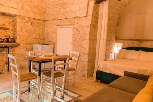 a room with a bed and a table and chairs at La Casedda - Apartment & Hydromassage in Ceglie Messapica