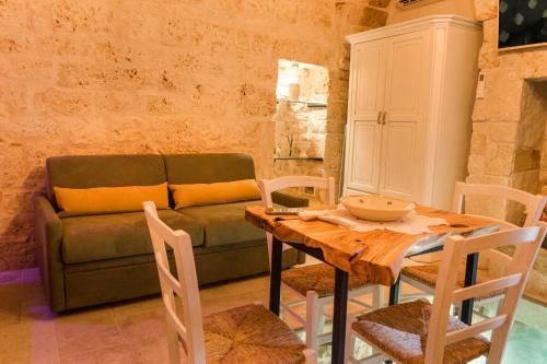 a living room with a table and a couch at La Casedda - Apartment & Hydromassage in Ceglie Messapica