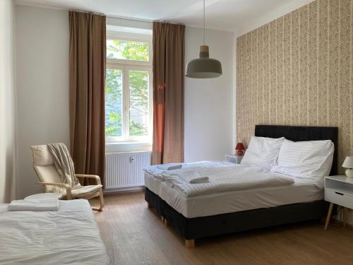 布拉格的住宿－Žižkov tower suites，一间卧室设有两张床、一把椅子和一个窗户。