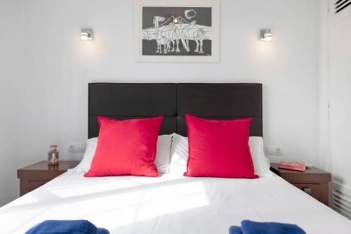 una camera con un letto con due cuscini rossi di Puerto Chico M a Playa Blanca