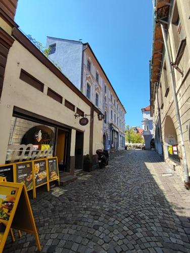 a cobblestone street in a city with a store at Apartament Podcienie z tarasem Bielsko-Biała Old Town in Bielsko-Biala
