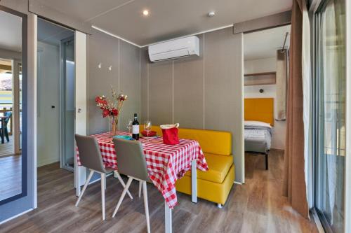 a dining room with a table and chairs and a bedroom at Campeggio Amici di Lazise in Lazise