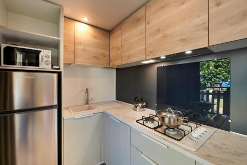 a kitchen with white cabinets and a stainless steel refrigerator at Campeggio Amici di Lazise in Lazise