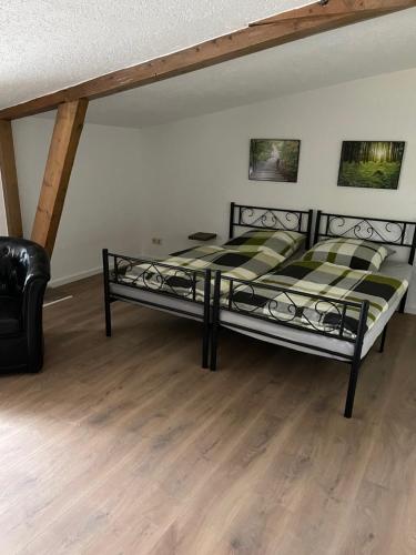 a bedroom with a bed and a leather chair at Radlerzimmer Neu Gaarz für 2 Personen in Neu Gaarz