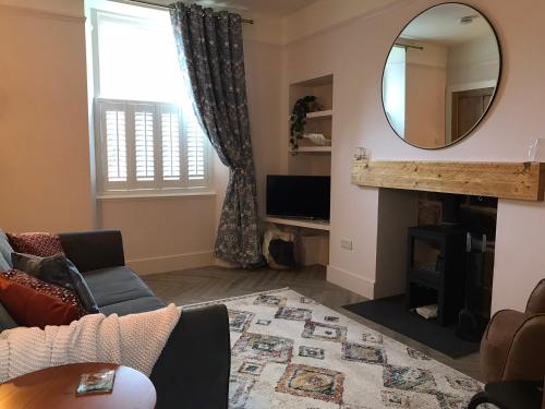 a living room with a mirror and a couch at Newly renovated seaside townhouse with logburner in Nairn