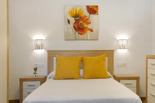 a bedroom with a bed with yellow pillows at Finca Rural Mar de Nubes in Vega de San Mateo