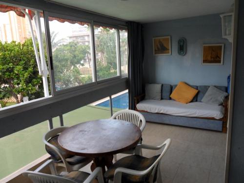 a room with a table and chairs and a couch at Apartamentos Cervantes in Benidorm