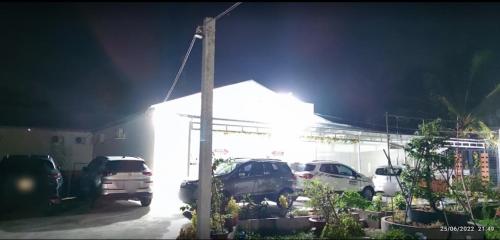 a parking lot with cars parked in front of a building at Nhà nghỉ Trúc Mây in Ben Tre