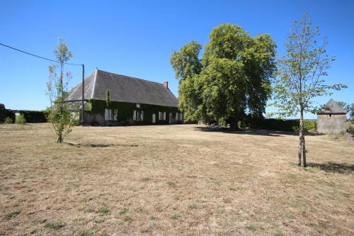 ein altes Haus mit einem Feld und Bäumen davor in der Unterkunft Varigny 