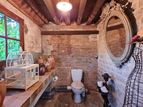 ein Bad mit einem WC in einer Ziegelwand in der Unterkunft Varigny 