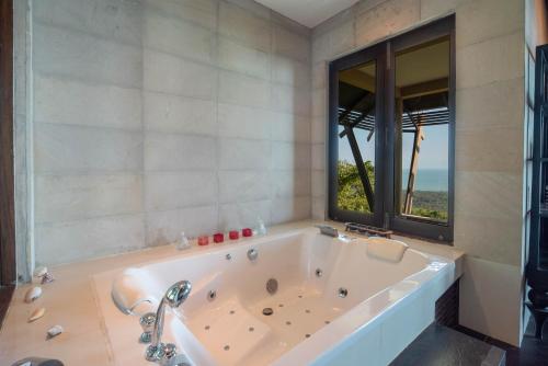 a bath tub in a bathroom with a window at Samui Ridgeway Villa - Private Retreat with Panoramic Sea Views in Koh Samui