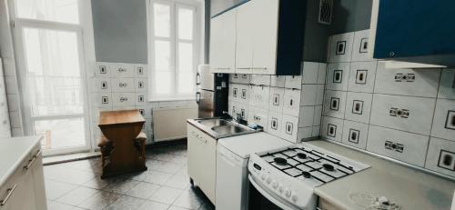 una cucina bianca con piano cottura e lavandino di Tanie Spanie przy City Park - Zameldowanie Bezobsługowe - a Poznań