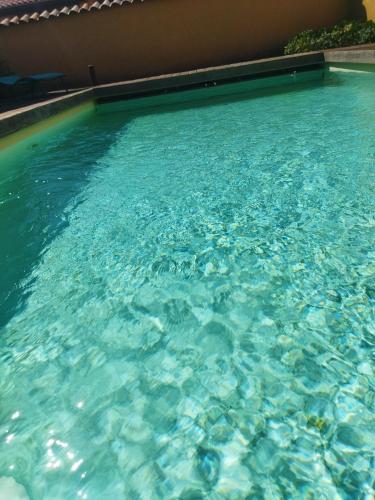 une grande piscine avec de l'eau bleue dans l'établissement La ferme du vincent, à Liergues