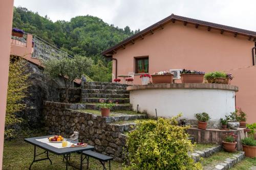 een klein huis met een stenen muur en een tafel bij Agriturismo Terrerosse Di Massadita in Aieta