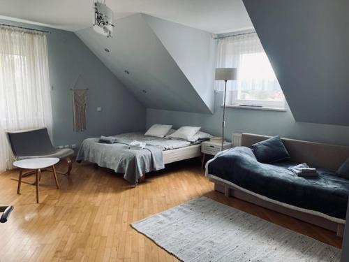 - une chambre avec un lit, un canapé et une chaise dans l'établissement Willa Na Wzgórzu, à Masłów