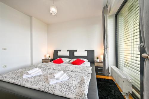 a bedroom with a large bed with red pillows at Exclusive apartment in Varaždin in Varaždin