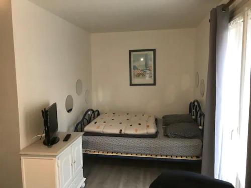 une chambre avec un lit et une télévision dans l'établissement Studio le treport, au Tréport