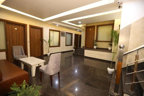 a lobby with a couch and a table and chairs at Hotel Lavit Couple Friendly near Faridabad Metro station in Faridabad