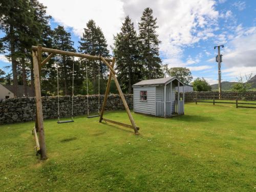 a playground with a swing set in a yard at Ash in Newtonmore