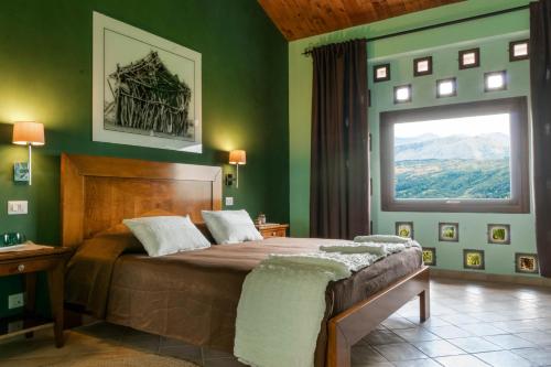 een slaapkamer met een bed met groene muren en een raam bij Agriturismo Terrerosse Di Massadita in Aieta