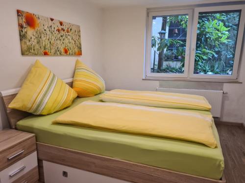a bedroom with two beds with yellow sheets and a window at Ferienwohnung Zilliken in Treis-Karden