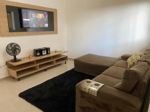 sala de estar con sofá y TV de pantalla plana en Recanto FF, en Olímpia