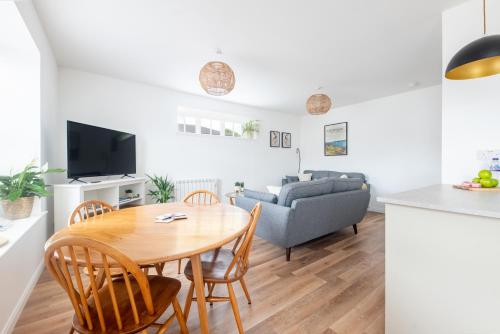 a kitchen and living room with a table and a couch at End House Inverness in Inverness
